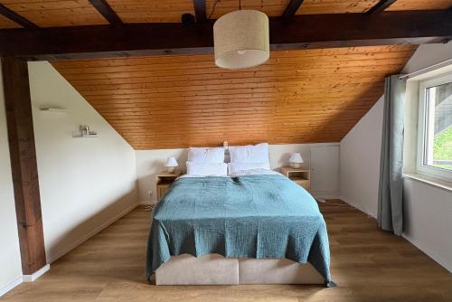 a bedroom with a bed with a wooden ceiling at Ferienwohnung Bergblick Bad Staffelstein in Bad Staffelstein