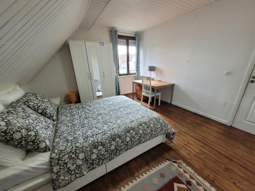 a bedroom with a bed and a desk and a window at La Chambre Claire in Strasbourg