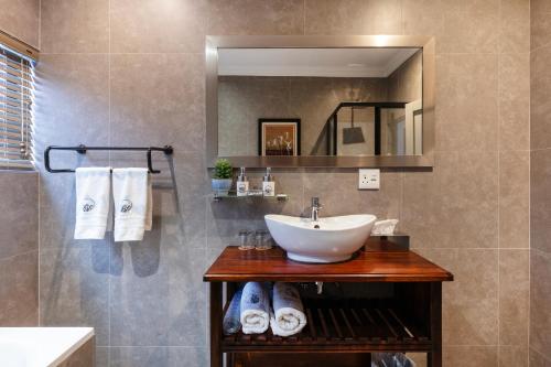 a bathroom with a sink and a mirror at Sasavona Boutique Hotel in Polokwane