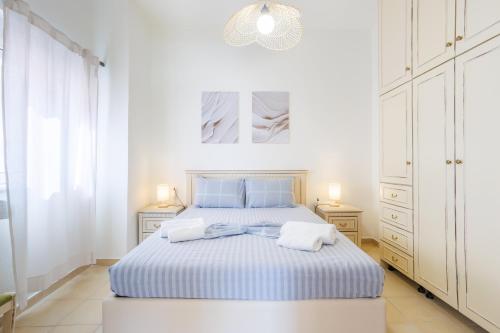 a white bedroom with a blue bed and white cabinets at Thalassini in Daratso