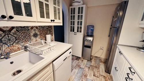 a kitchen with a sink and a refrigerator at Çeşme Seaside House in Çeşme