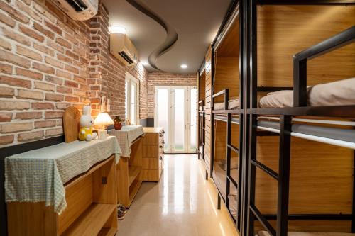 a room with two bunk beds and a brick wall at Saigon Box Hostel in Ho Chi Minh City