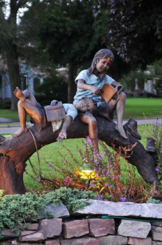 a statue of a man sitting on a tree stump at Lockport Inn and Suites in Lockport