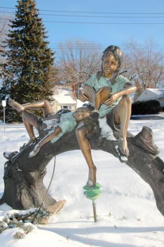 a statue of two children sitting on a tree branch at Lockport Inn and Suites in Lockport