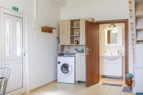 a laundry room with a washing machine and a sink at Thalassini in Daratso