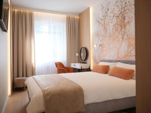 a bedroom with a large white bed and a window at Apartament MAXIM in Słupsk