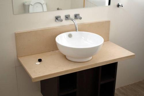 a white bowl sink on a counter in a bathroom at Talu Apart Hotel in San Rafael