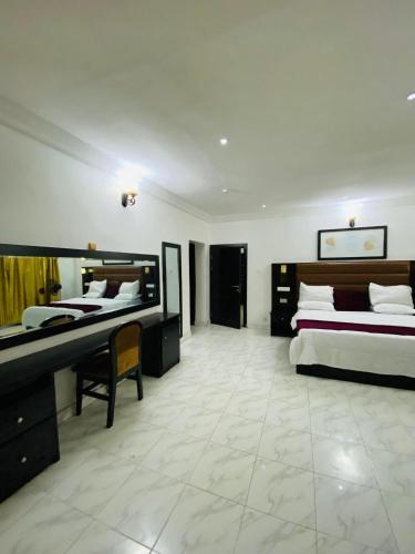 a bedroom with two beds and a desk in it at Unique luxury duplex in Lekki