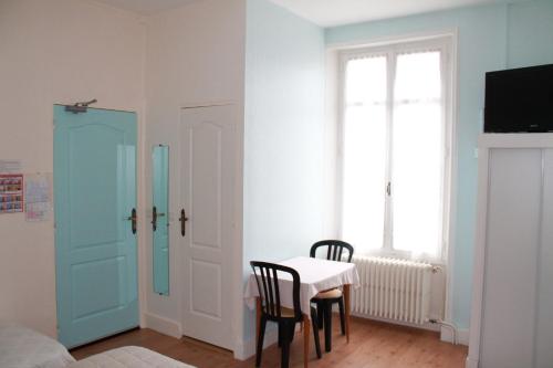 a room with a table and chairs and a window at Logis Hôtel Beauséjour in Chauvigny