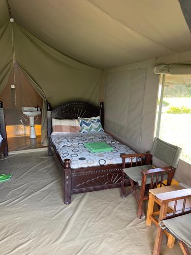 a bedroom with a bed in a tent at Ntito Mara lodge in Maasai Mara National Reserve
