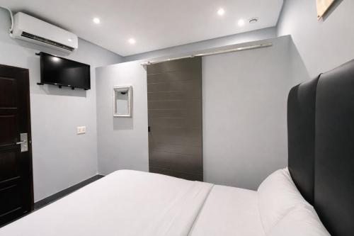 a bedroom with a white bed and a closet at Hotel Metro Lodge Xpress in Durban