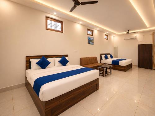 a hotel room with two beds and a chair at Shree Sita Sadan in Ayodhya