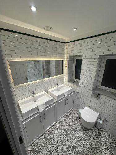 a bathroom with three sinks and a toilet at The View At Alison Avenue in Bristol