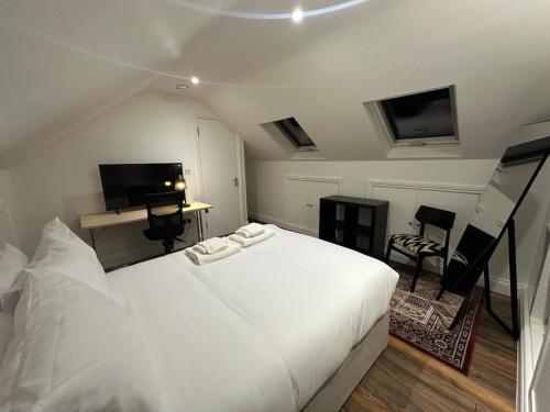 a bedroom with a large white bed and a television at The View At Alison Avenue in Bristol