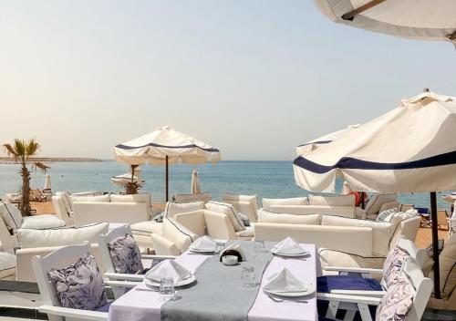 a group of tables and umbrellas on a beach at Paradise Inn Beach Resort in Alexandria