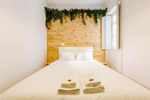 um quarto com uma cama com duas toalhas em The Palm Leaf - SOC em Lisboa