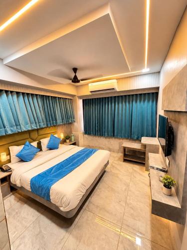 a bedroom with a large bed and a television at Hotel Apollo Sp Ring Road Odhav Ahemdabad in Ahmedabad
