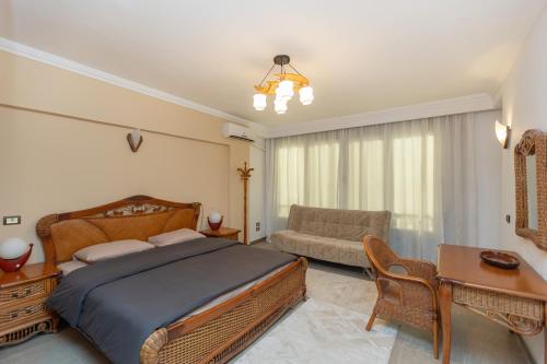 a bedroom with a bed and a table and a couch at 3BR Beach Front Chalet On RedSea in Ain Sokhna