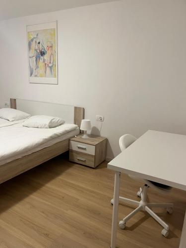 a bedroom with a bed and a desk and a table at Janez house in Metlika