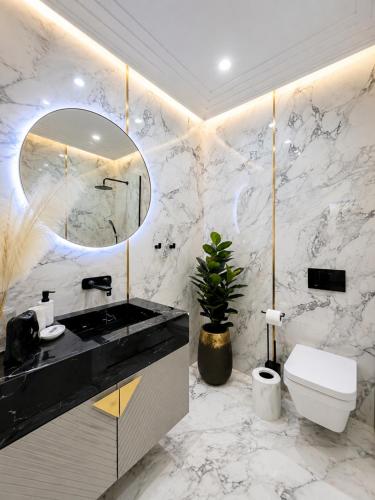 a bathroom with a sink and a toilet and a mirror at FIRST RESIDENCe in Mamaia