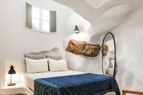 a bedroom with a bed and a rock on the wall at Timedrops Santorini Villas-Private pool in Emporio