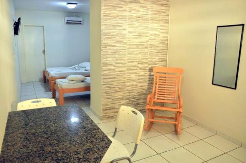 Pousada Serra Negra في بيزيروس: غرفة مع طاولة وكراسي وغرفة نوم