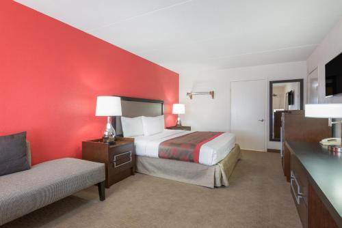 a hotel room with a bed and a couch at Ramada by Wyndham Albuquerque Airport in Albuquerque