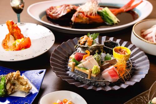 a table with plates of food on a table at Inatori Tokai Hotel Yuen in Higashiizu
