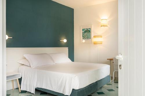 a bedroom with a white bed and a blue wall at Hotel Oasi Castiglione in Casamicciola Terme