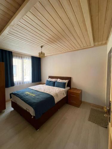 a bedroom with a bed with a wooden ceiling at Nirvana Suite Hotel in Uzungöl