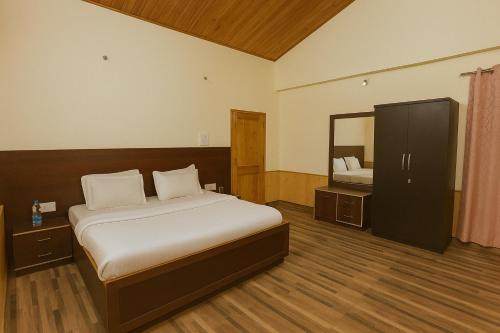 a bedroom with a bed and a large mirror at Chaman Vatika in Kasol