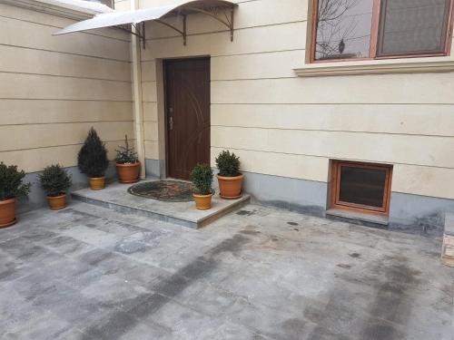 uma porta da frente de uma casa com vasos de plantas em La Vacanza em Yerevan