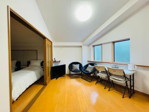 a bedroom with a bed and a table and chairs at KiyomizuGaku Guesthouse in Keage