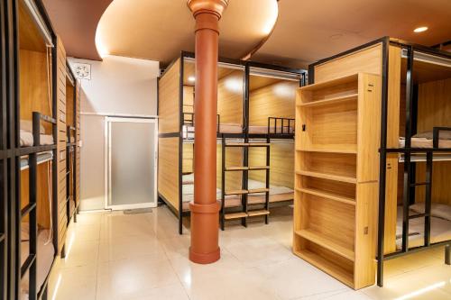 a pipe in the middle of a room with wooden cabinets at Saigon Box Hostel in Ho Chi Minh City
