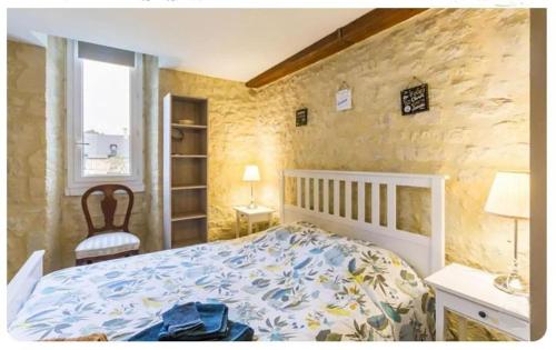 a bedroom with a bed and a stone wall at Chez Les Ch'Tis in Commes