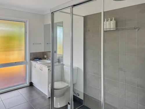a bathroom with a shower with a toilet and a sink at Spotted Gum -Merrijig in Merrijig
