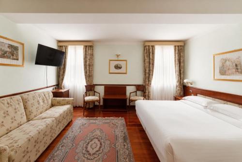 a hotel room with a bed and a couch at Phi Hotel Dei Medaglioni in Correggio