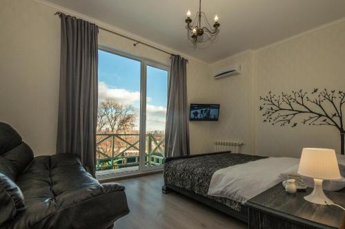 a bedroom with a bed and a couch and a large window at Mini Hotel Ryleev in Kharkiv