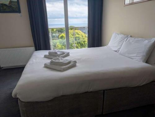 a bed with towels on top of it with a window at Coastguard cafe room 2 in Hastings