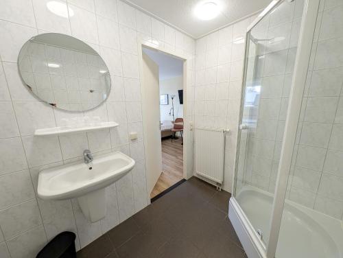 a white bathroom with a sink and a shower at Hotel B&B d'Olde Smidse in Giethoorn