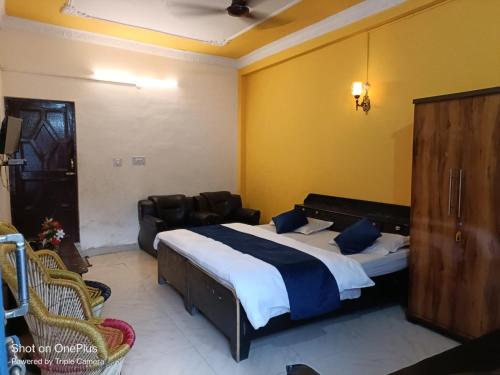 a bedroom with a bed and a couch in a room at Hotel Omkaar & Restaurant Chinyalisaur in Chhām