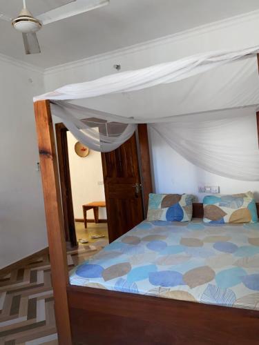 a bed with a canopy in a room at Simai house in Nungwi