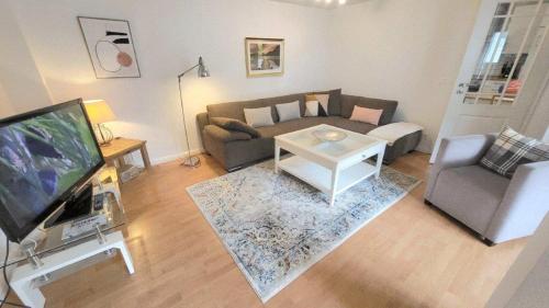 a living room with a couch and a tv at Ferienhaus Friedrich-Borge-Straße in Kühlungsborn