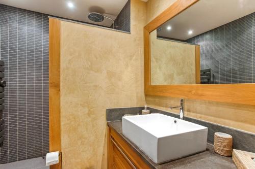 a bathroom with a white sink and a mirror at Appt Ramatuelle - Plage Pampelonne in Ramatuelle