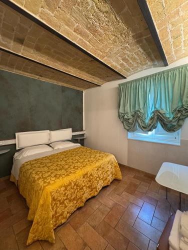 a bedroom with a bed with a yellow blanket at Regis Resort & Wellness in Turrivalignani