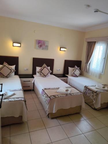 a hotel room with two beds in a room at Canna Garden Hotel - Adult Only in Gümbet