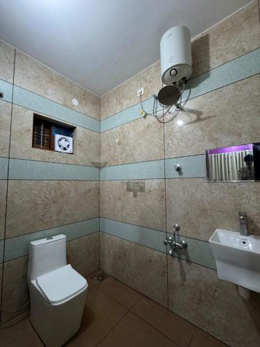 a bathroom with a toilet and a sink at Mountain pride homestay in Meppādi