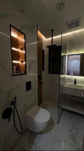 a bathroom with a toilet and a sink at شقة فندقية غرفة نوم وصالة in Hail