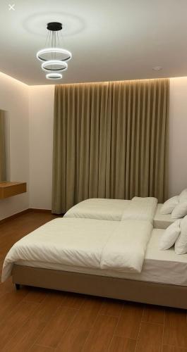 a large bed in a bedroom with a chandelier at شقة فندقية غرفة نوم وصالة in Hail