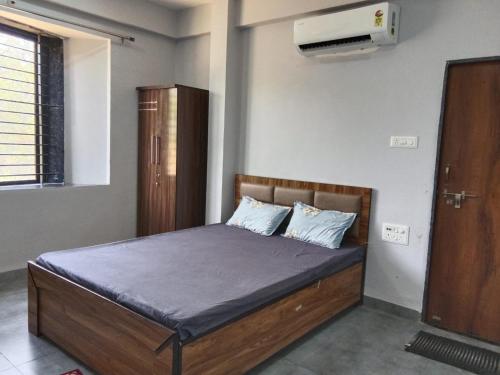 a bedroom with a bed with blue sheets and a fan at Raghav Sarkar Parisar in Indore